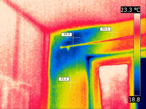 Infrarotbild, auf dem die Feuchtigkeitsbildung in einer Zimmerecke gut zu erkennen ist.